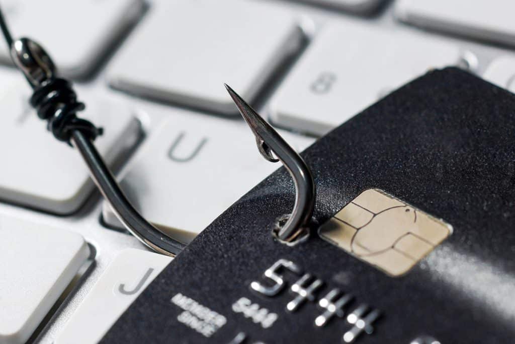 credit card being hooked by a fishing hook illustrating phishing that is done by hackers