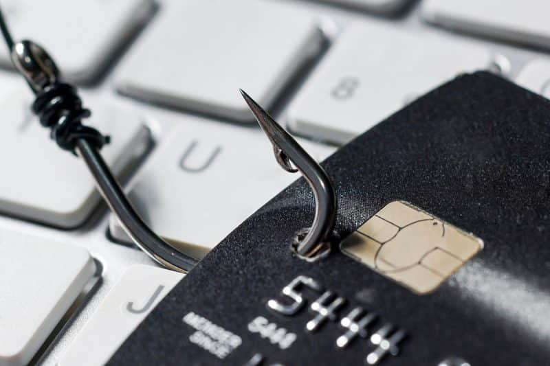 credit card being hooked by a fishing hook illustrating phishing that is done by hackers